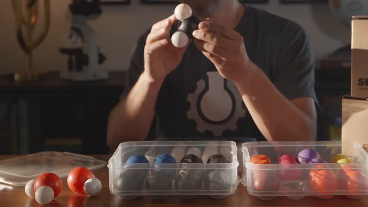 A close-up demonstration of the magnetic Snatoms X molecular modeling kit, showing how the individual atom pieces snap together.