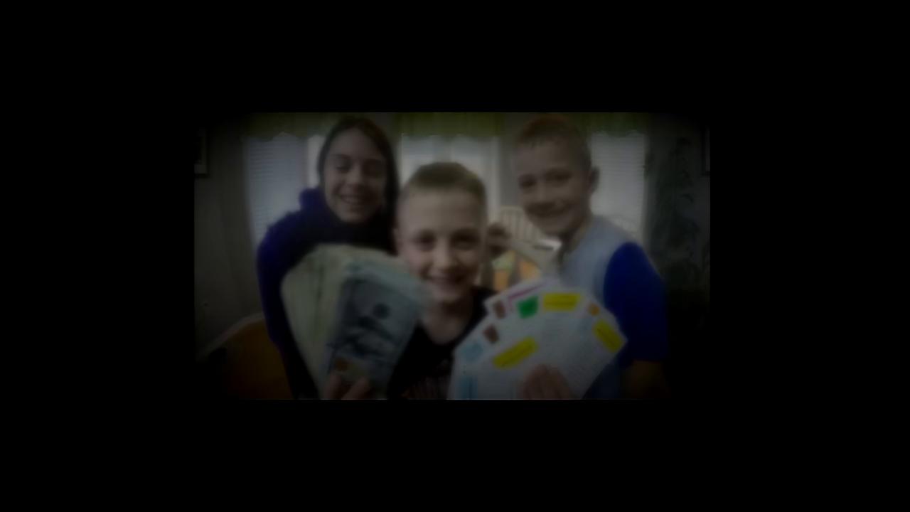 showing a photo of three children holding large amounts of cash and Monopoly property cards.