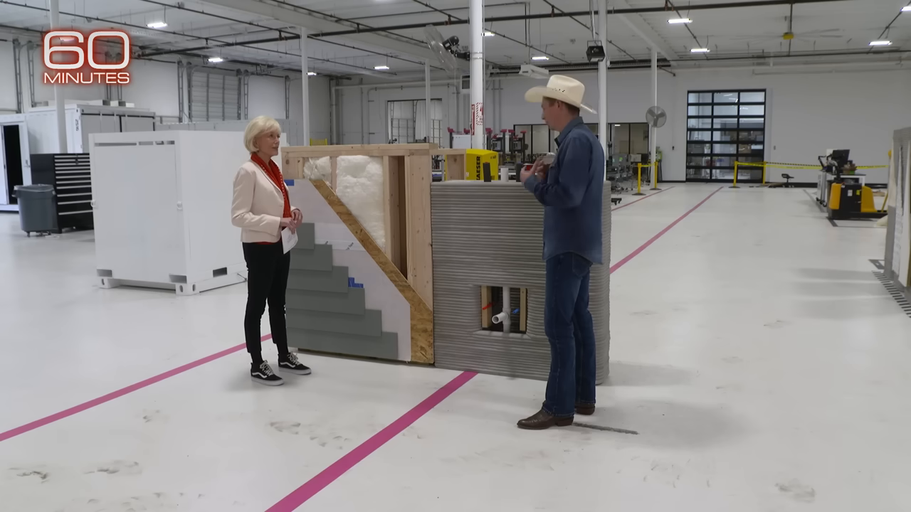 Side-by-side physical mockup showing the many layers of a traditional stick-built wall versus a solid 3D printed wall.